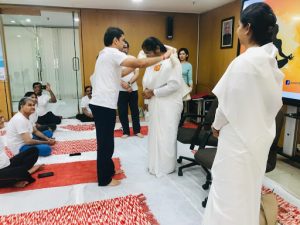 Soft and silky scarf in rose reds on sofa